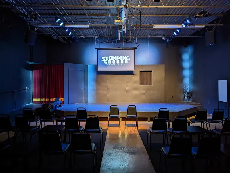 Empty house with a warm runway down the aisle and cool blue on the stage and walls