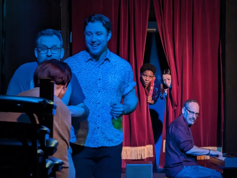 Performers bursting through red curtains in a cool blue wash, the accompanist at the piano