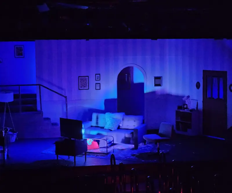 Empty set in moonlight blue, the archway and sofa catching cool top light